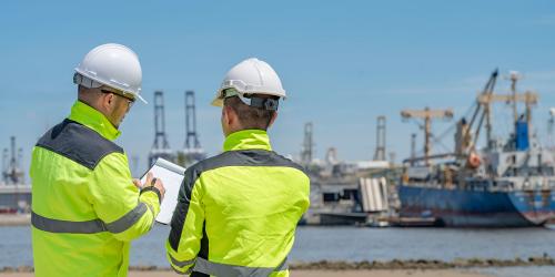 Two engineers inspecting a shipyard and ensuring quality of operations