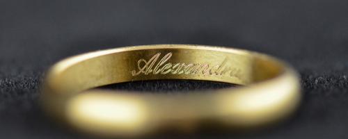 Ringgravur des Namens Alexandra auf einem goldenen Ehering