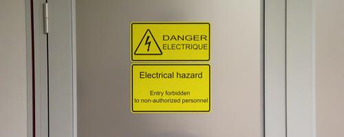 Lasergravierte Sicherheitsbeschilderung aus Gravoply™ Laser an einem Industrietor für die Sicherheit am Arbeitsplatz
