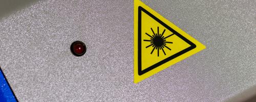 Gelbes dreieckiges Laserwarnschild auf Flexilase™ Graviermaterial