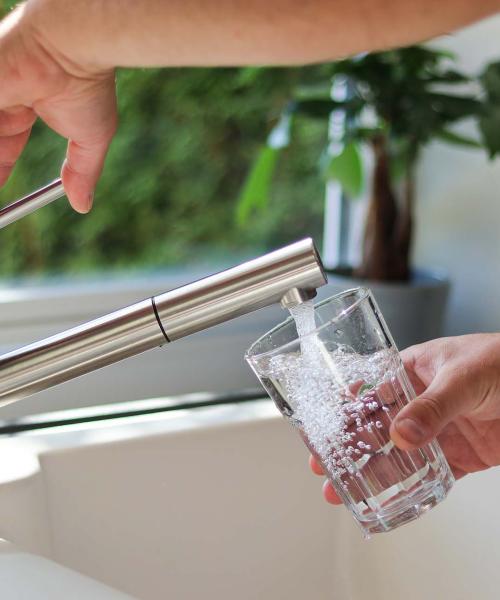 Drinking water faucet filling up a glass